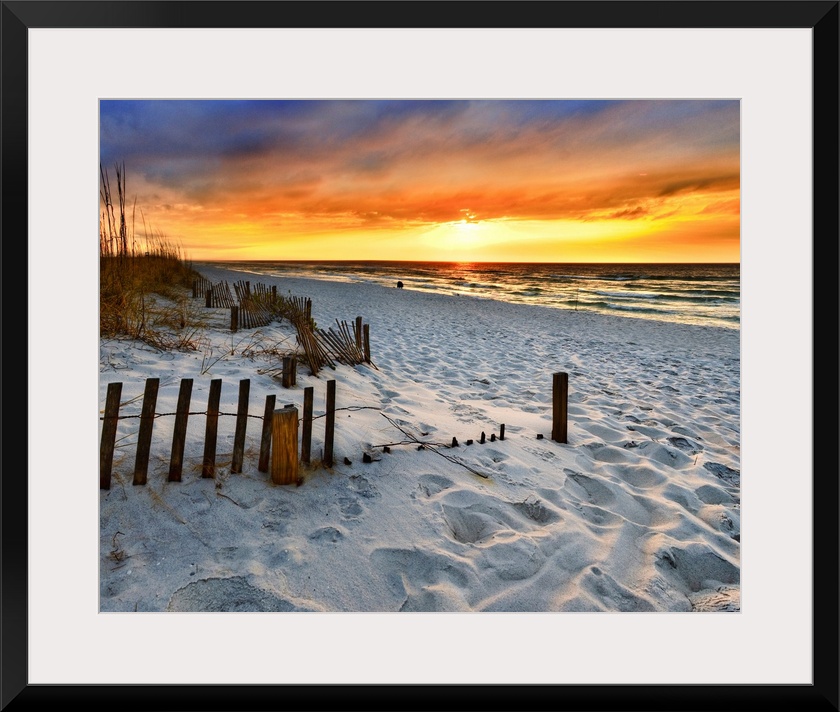 A sandy beach before a bright red sunset on the beach. The sand in This part of Florida is bright white. Landscape taken o...