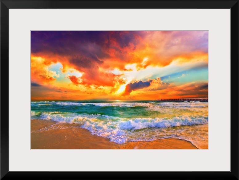 A red, orange and purple sunset on the beach. Beautiful ocean waves roll onto the sea shore.