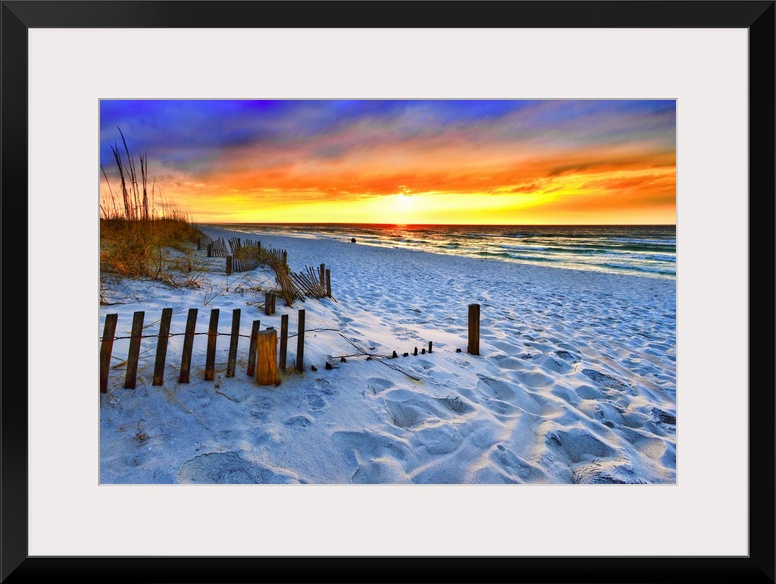 A dark burning red sunset on the beach in this beautiful landscape. A burning sun sets in the distant sea beyond a sandy s...