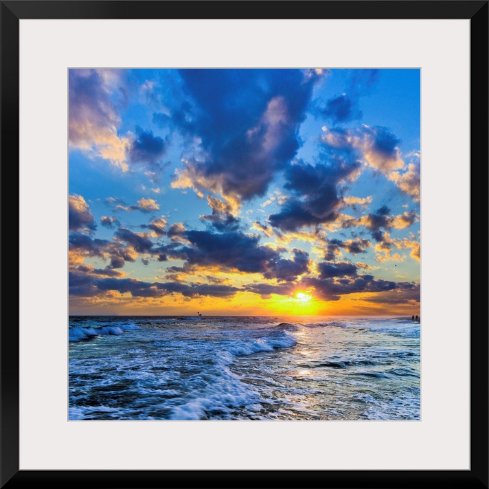 A Florida sunset with expanding puffy blue clouds during winter.