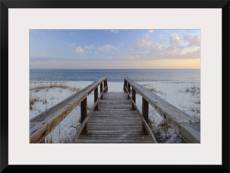 Photograph of a wooden walkway leading to the sandy beach with a Pensacola sunset