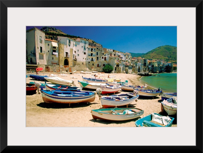 Huge photograph showcases a fleet of small water vessels sitting on top of a sandy beach within the largest island of the ...