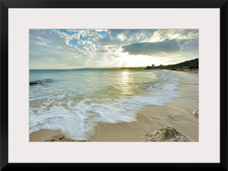 Nanwan, Kenting on  cloudy afternoon with foaming green sea water rushing in onto sandy beach with coral reefs and strong ...