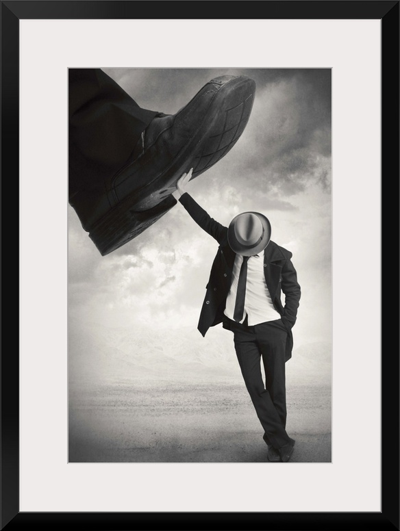 An abstract art photograph of a man wearing a hat and suit, leaning against a giant foot trying to step on him.