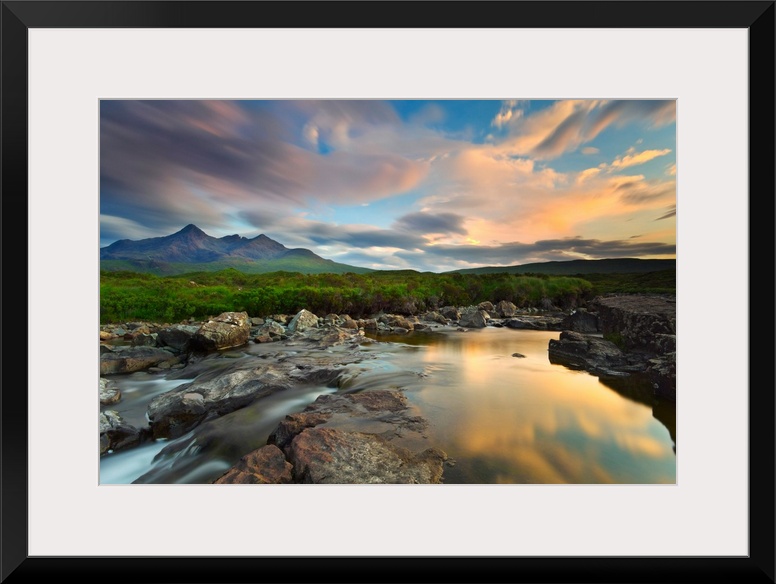 Isle of Skye, Scotland, Europe. The last sunset colors reflected in the water. In the background the peaks of the Black Cu...