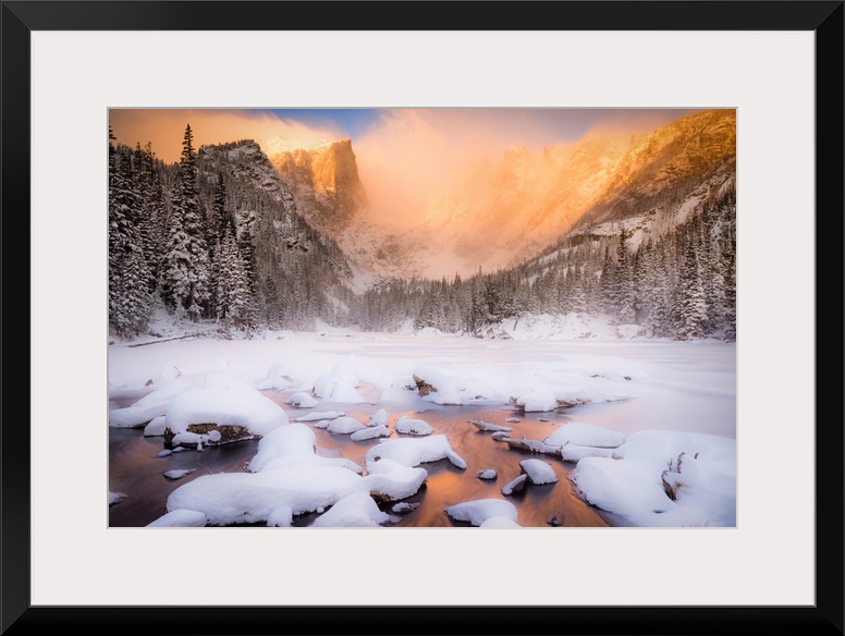 Giant photograph of a snow covered landscape filled with trees surrounding and a frozen river running down the center of t...