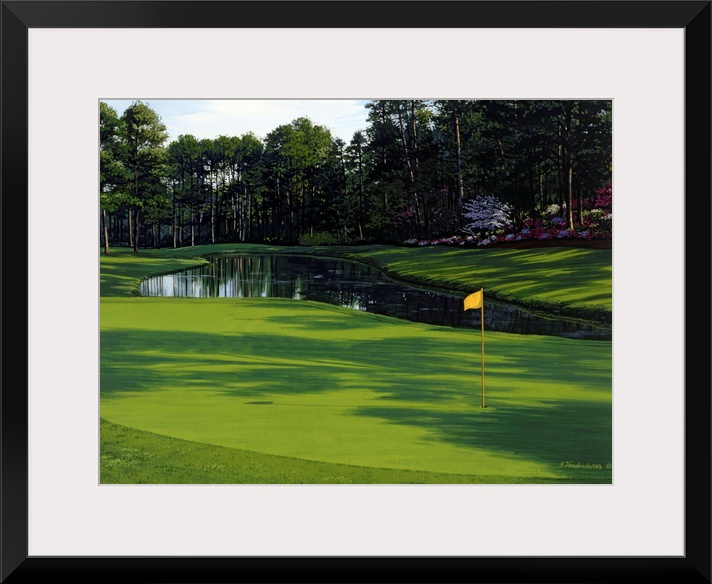 Photograph of the greenway on a golf course with a small pond and trees just behind it.