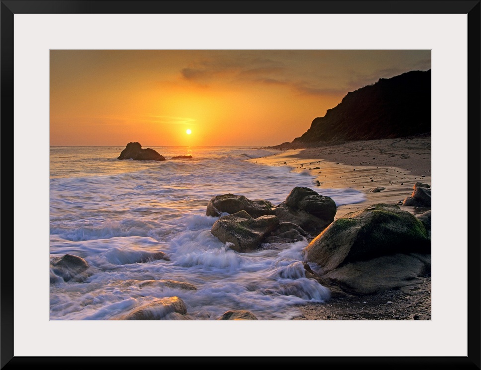Large landscape photograph of a golden sunset over the rocky shoreline at Leo Carrillo State Beach, Malibu, California.