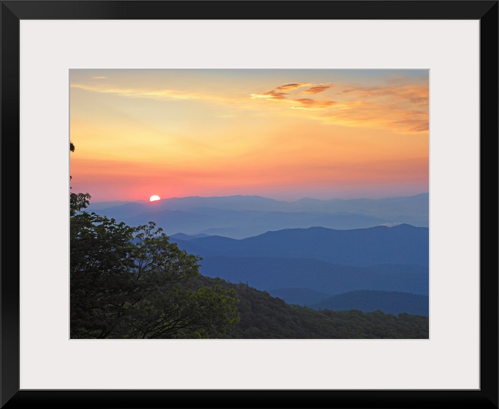 Photo of the sun setting over the mountains from the Blue Ridge Parkway in North Carolina.