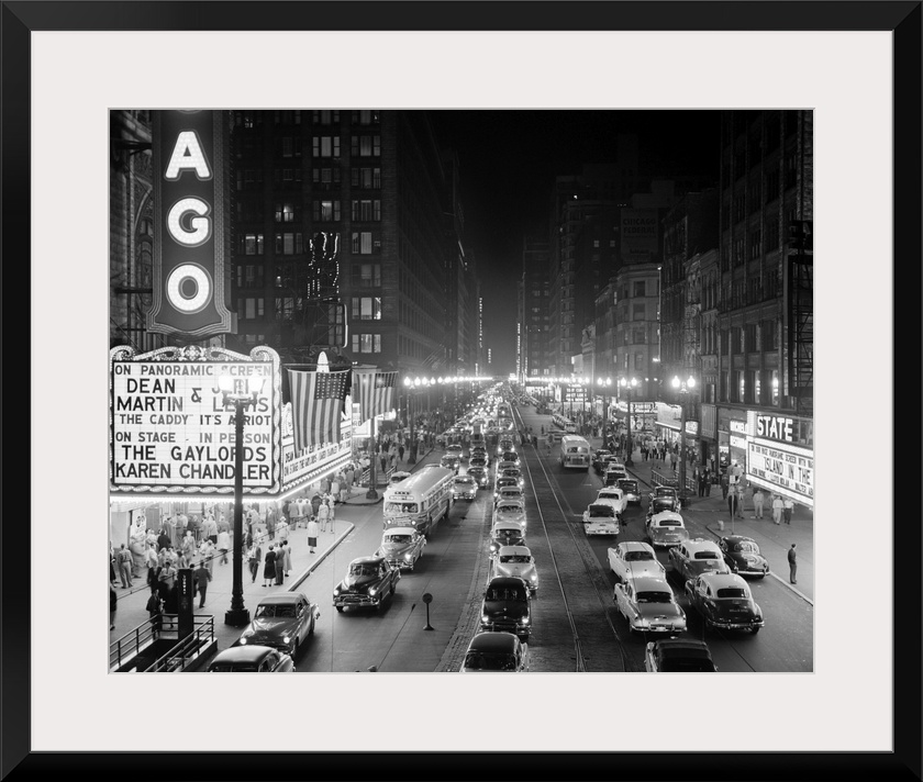 1950's 1953 Night Scene Of Chicago State Street With Traffic And Movie Marquee With Pedestrians On The Sidewalks.