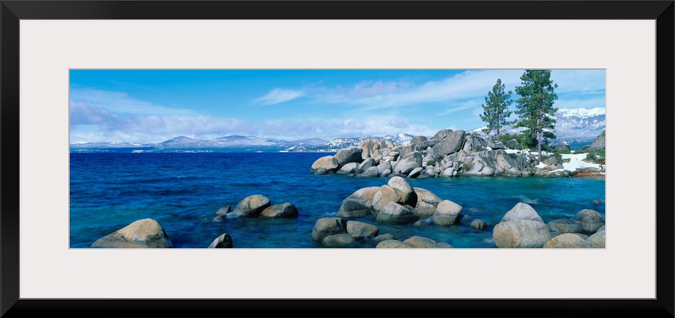 A panoramic photograph taken at eye level this home wall art shows the boulder covered shores of this world renowned lake.