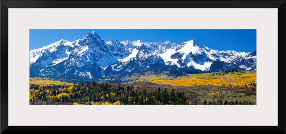 Panoramic image of a wilderness area at the base of a snowy mountain range.