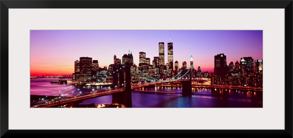 Large artwork for a living room of office of the Brooklyn Bridge and Manhattan with lights shining in the evening sky.
