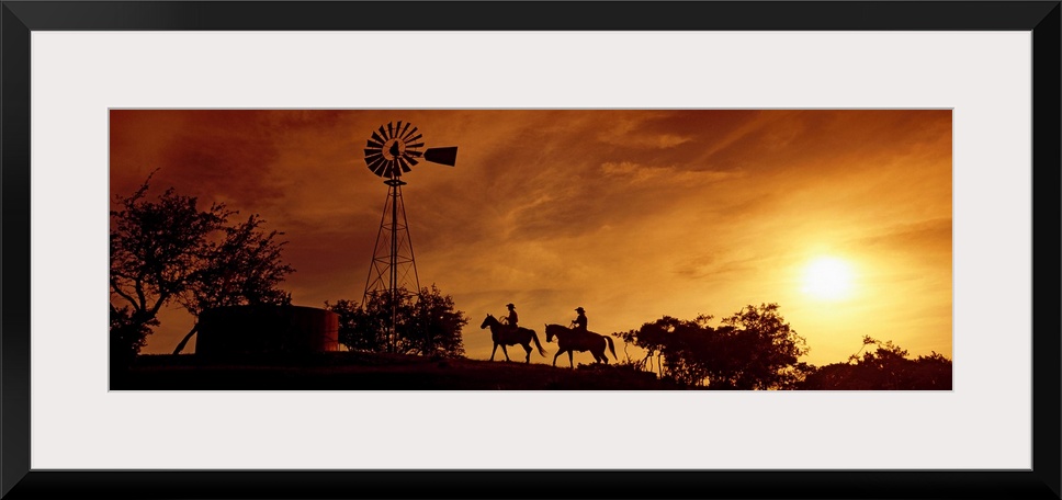 Landscape, panoramic artwork of a hill with a windmill perched at the top on a farm at twilight.