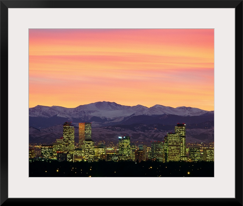 Large photograph taken of the Denver, Colorado skyline at dusk.  The snow covered mountains in the background provide a gr...