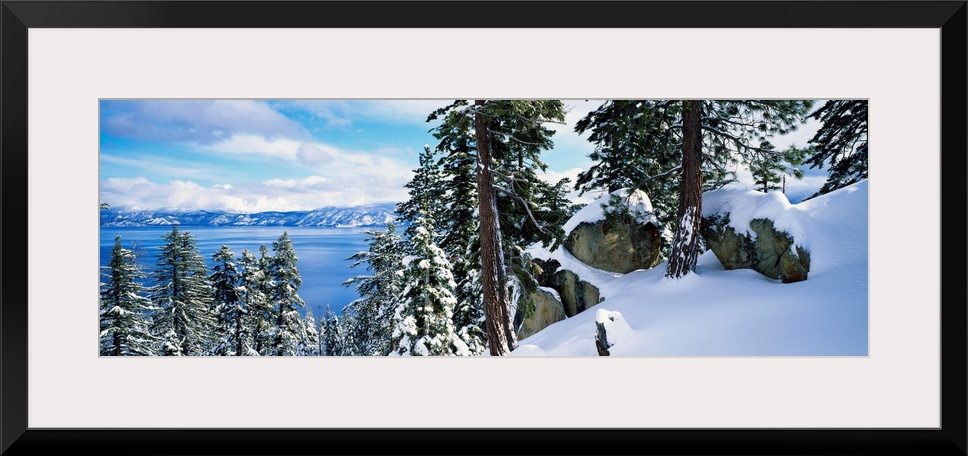 A landscape photograph taken from a mountain ridge in winter looking down into the scenic lake and wilderness.