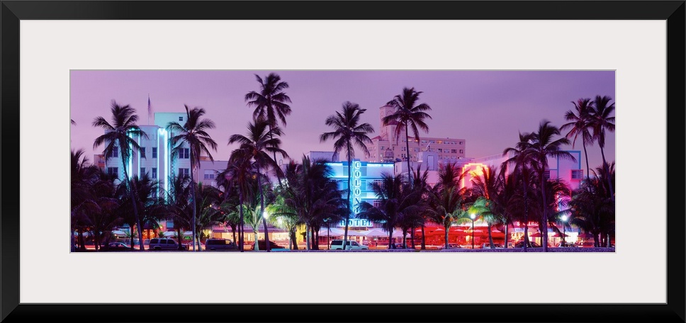 View from the shore of Ocean Driveos art deco neon signs and palm trees.