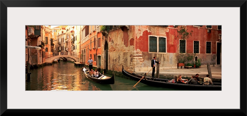 Gondolas paddling through canals lined with historic Venetian buildings.