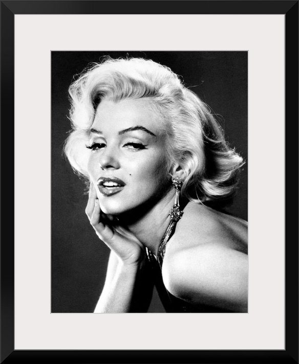 Large, portrait, black and white photograph of Marilyn Monroe, leaning forward with her palm on her face.