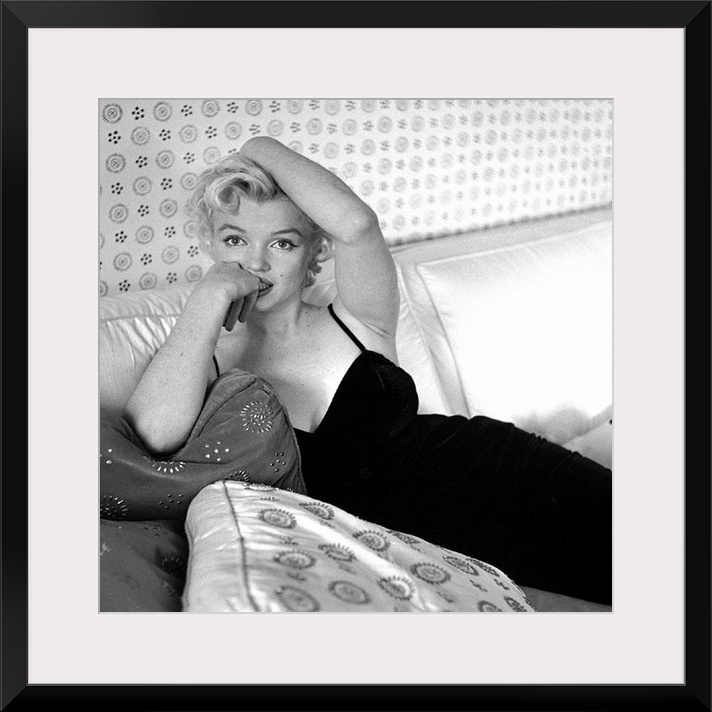 Wall art of Marilyn Monroe sitting on a sofa looking at the camera.