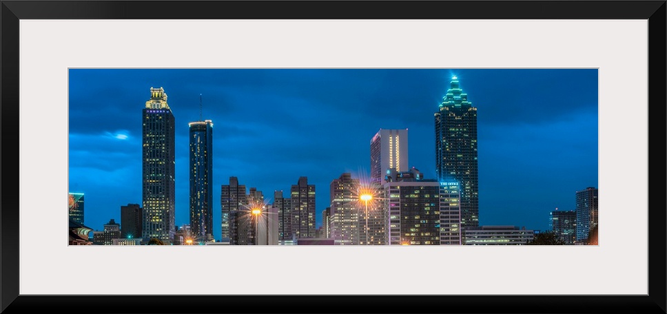 Skyscrapers in Atlanta, Georgia, illuminated at night against a deep blue sky.