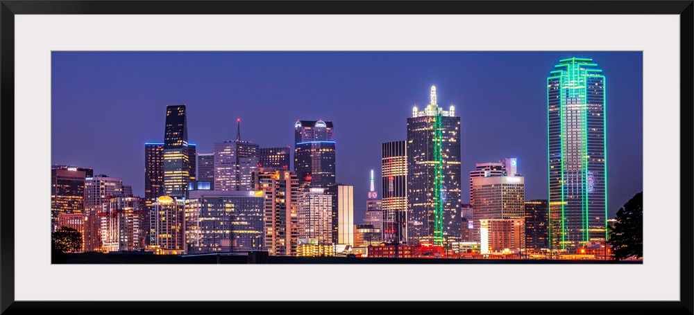 A horizontal image of the Texas city skyline at night.