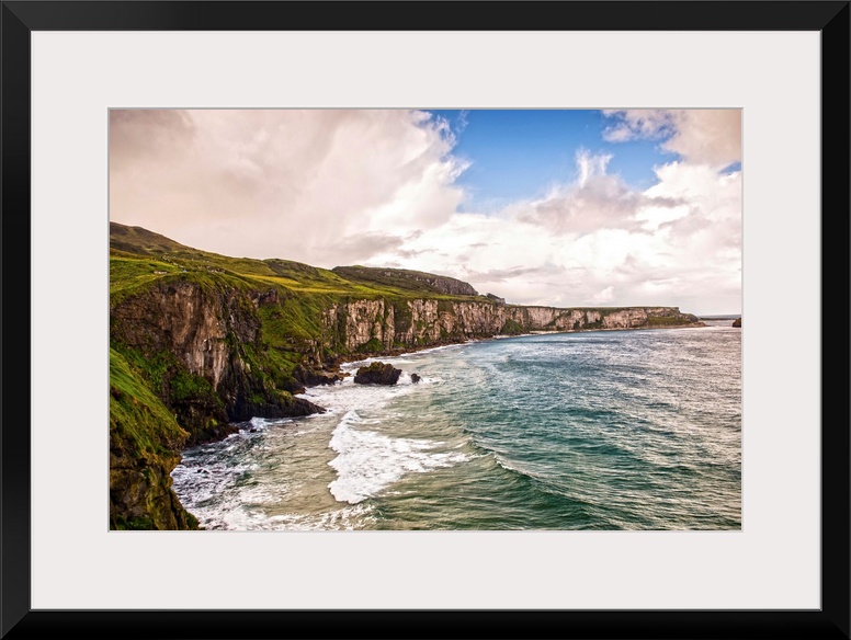 Landscape photograph of the picturesque Cliffs of Moher with a cloudy sky above, located at the southwestern edge of the B...