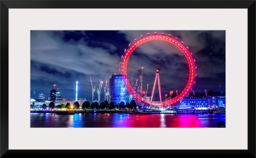 View of the brightly colored ferris wheel at night in London, England.