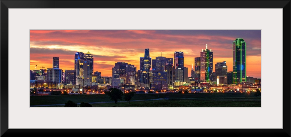 A horizontal image of the Dallas, Texas city skyline with a brilliant sunset.