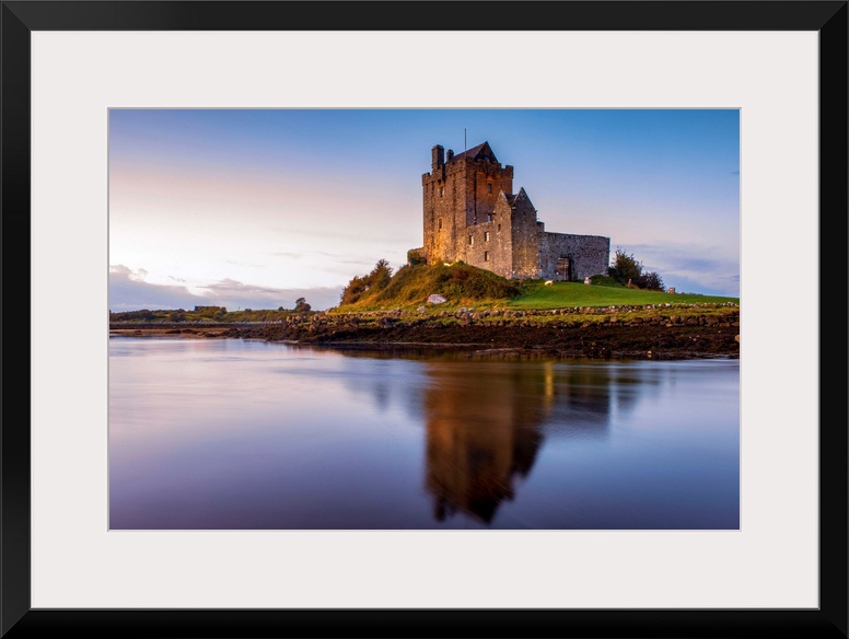 Landscape photograph of the Dunguaire Castle reflecting into the water on the southeastern shore of Galway Bay in County G...