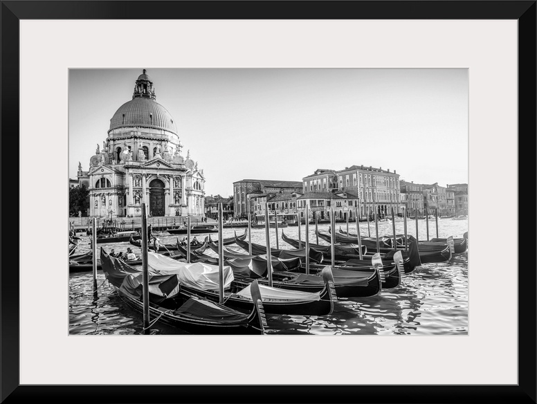 Photograph of gondolas lined up in a row in front of Santa Maria della Salute, Venice, Italy, Europe.