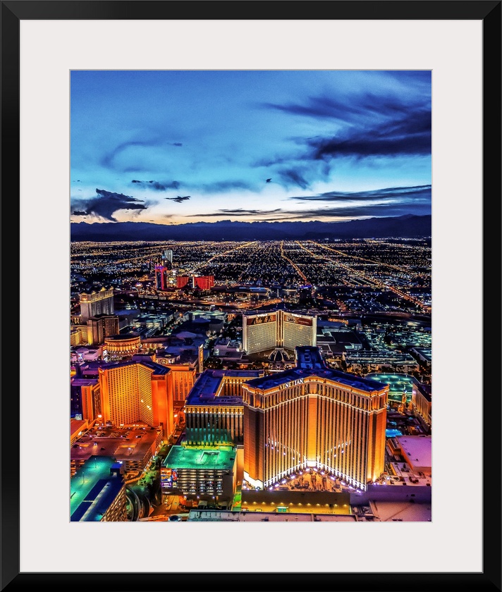 Aerial view of the Las Vegas Strip illuminated in the early evening with cloudy skies.