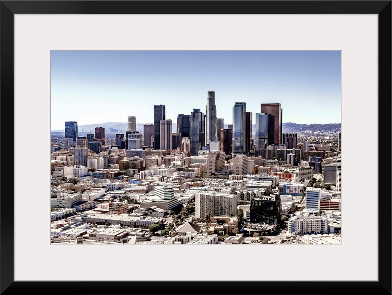 Skyscrapers and surrounding buildings of the Los Angeles skyline under a blue sky, California.