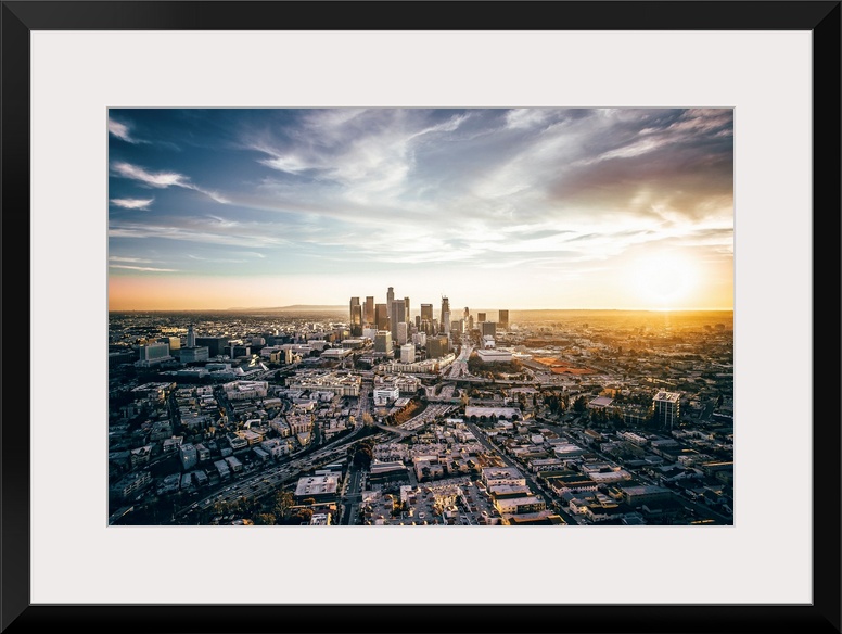 The setting sun visible behind the skyscrapers in the Los Angeles skyline, California.