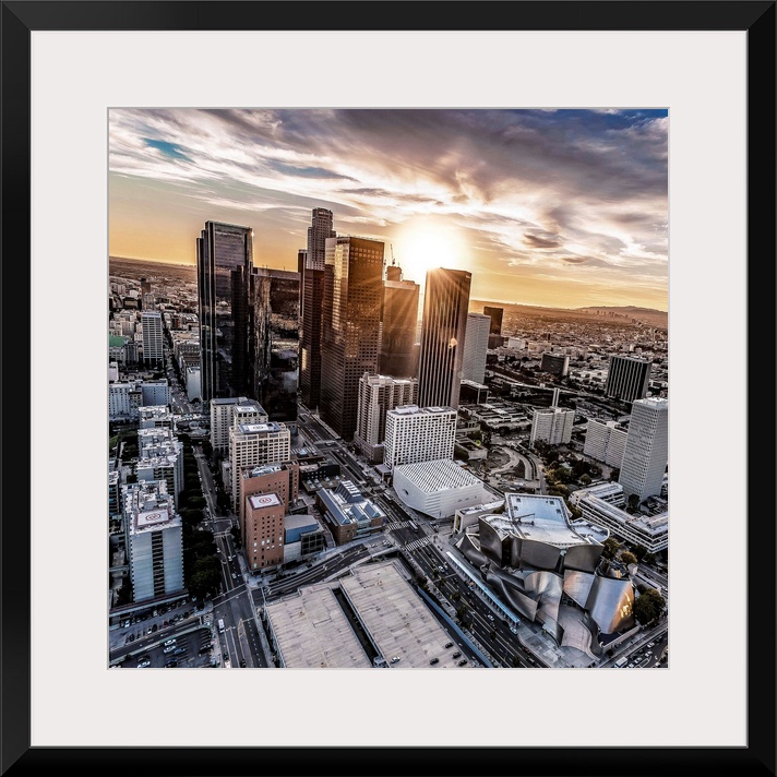 The setting sun visible behind the skyscrapers in the Los Angeles skyline, California.