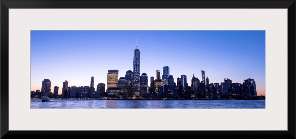 Panoramic view of the New York City skyline with the One World Trade Center tower, at night.