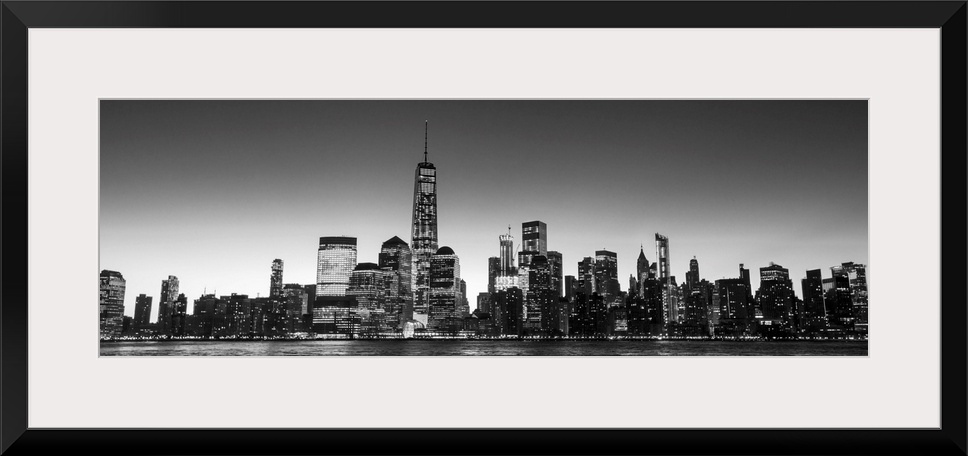 Panoramic view of the New York City skyline with the One World Trade Center tower, at night.