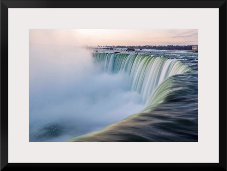 Water cascades down at Horseshoe Falls while dramatic mist ascents to meet the rising sun.