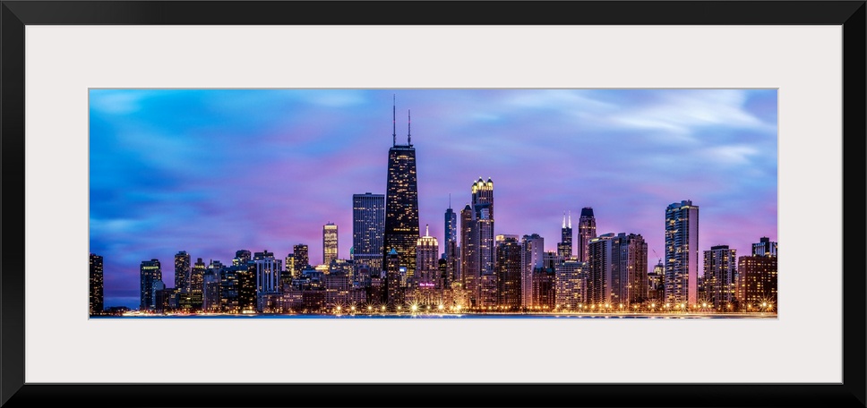 Photo of Chicago skyline at night under cotton candy colored clouds.