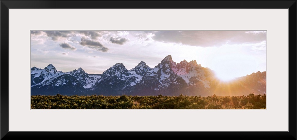 Panoramic view of the sun rising over Teton mountains in Wyoming.