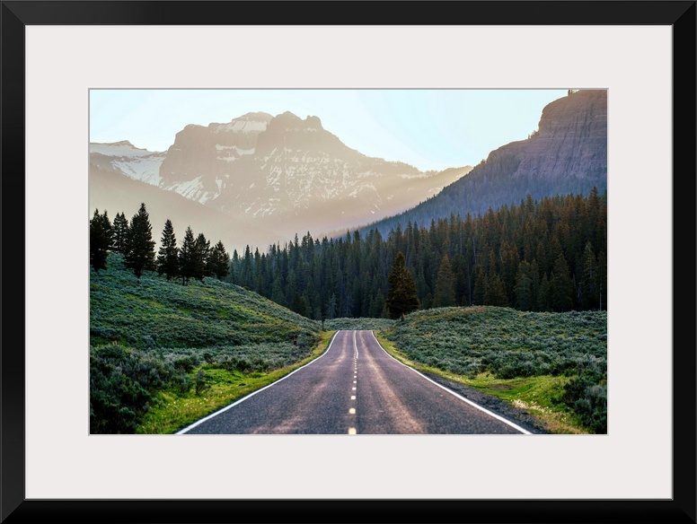 Horizontal image of a road heading to the mountains at Yellowstone National Park.