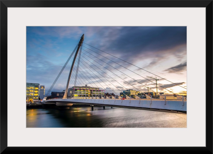 Photograph of the Samuel Beckett Bridge, a cable-stayed bridge in Dublin, Ireland going across the River Liffey, at sunset.