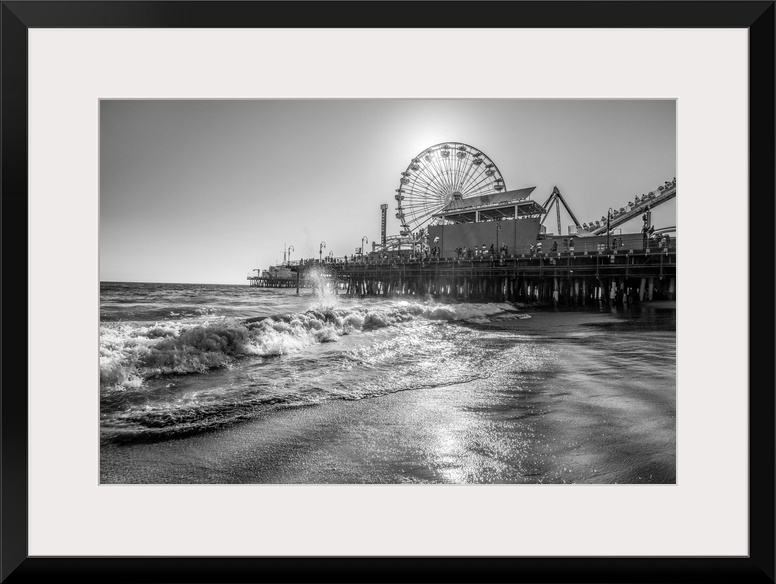 Photograph of the Santa Monica Pier in Los Angeles, California, with the sun setting right behind the Ferris Wheel.