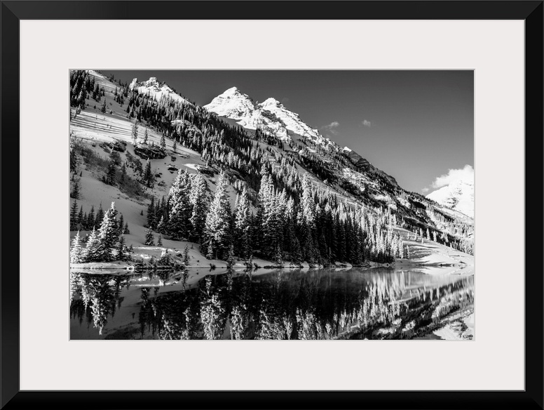 Summer snow on pine trees and the mountain side at the edge of Maroon Lake in the Maroon Bells, Aspen, Colorado.