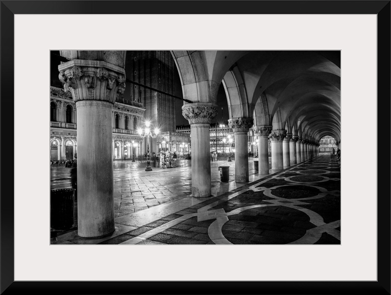Photograph of the view from underneath arches at night in St. Mark's Square, Venice.