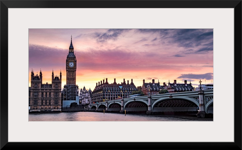 Panoramic photograph of Big Ben and the Westminster Bridge with a pink and purple sunset.