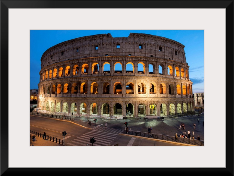 Photograph of the Colosseum lit up at dusk.