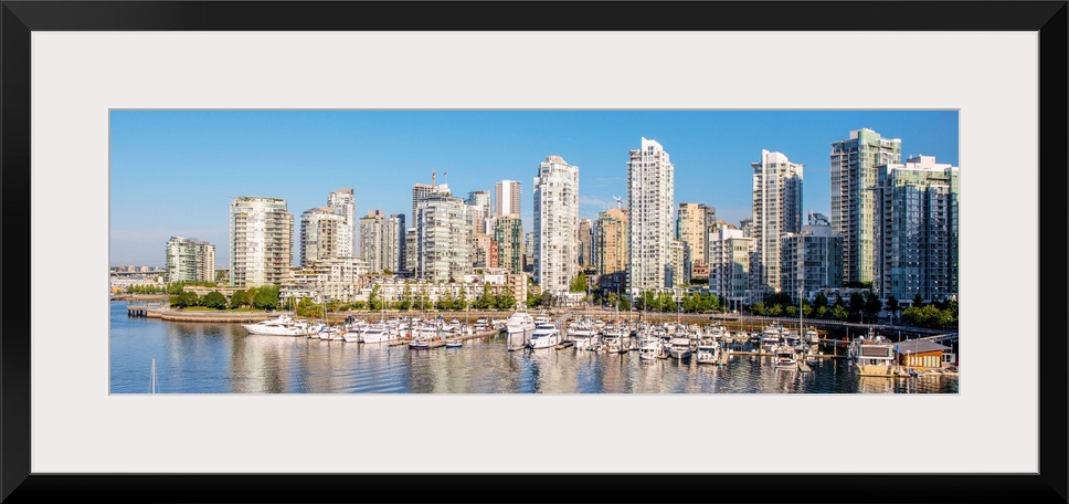 Panoramic photograph of part of the Vancouver, British Columbia skyline with False Creek Harbor and boats in the foreground.