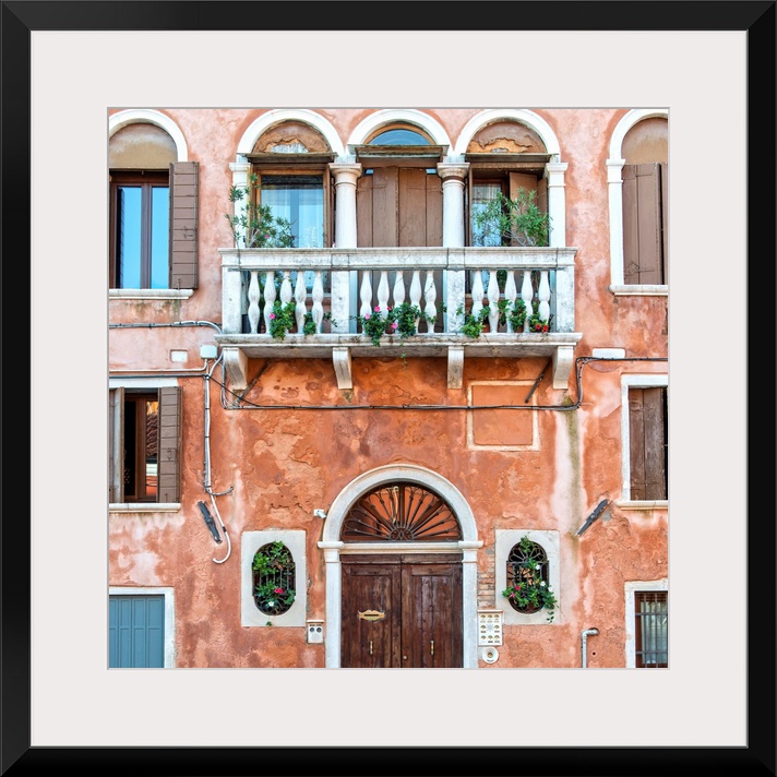 Square photograph of an Italian facade in Venice with a door, windows, and a balcony.