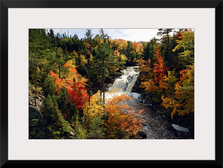 From the National Geographic Collection, a giant photograph shows a roaring waterfall making its way through a thick fores...